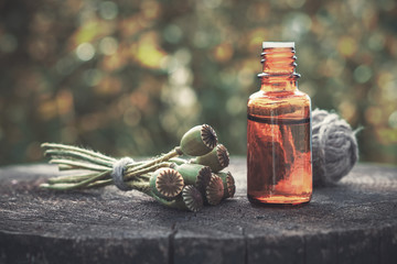 Wall Mural - poppies, poppy flower heads and bottle of infusion. herbal or homeopathic medicine.
