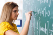 © Elnur - Young female student in front of the chalkboard