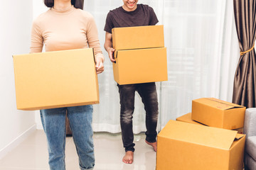 Wall Mural - Happy young couple holding box and moving into their new home.House moving and real estate concept