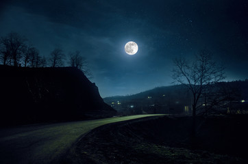Wall Mural - Mountain Road through the forest on a full moon night. Scenic night landscape of dark blue sky with moon. Azerbaijan