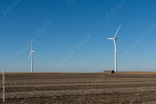 Fotografie, Obraz Old wooden barn and windmill in open farmland.