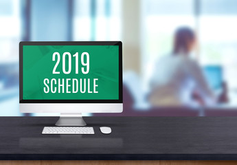 Aufkleber - 2019 schedule on desktop computer on black board wooden table top with blur people working at office desk bokeh background.