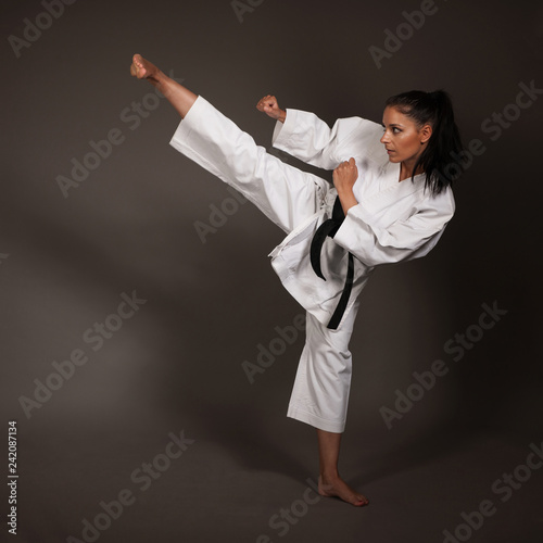 Plakaty Taekwondo  kobieta-w-bialym-kimonie-kopie-wysoko-w-powietrze-dziewczyna-sztuki-walki-karate
