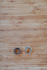 two wedding rings sitting on wooden table