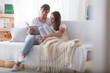 © Photographee.eu - Caregiver reading book to girl with blanket while relaxing at home