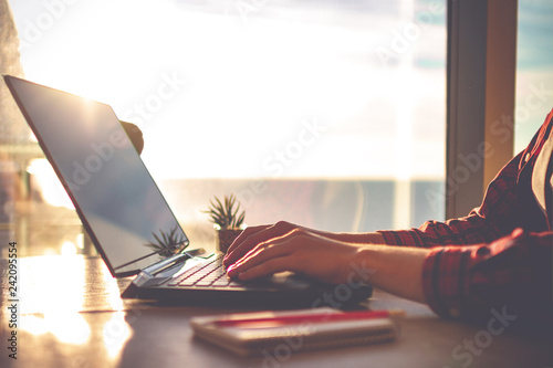 Fotografía Cozy workplace in home office with laptop on table against the windows at sunset for online business, working, study