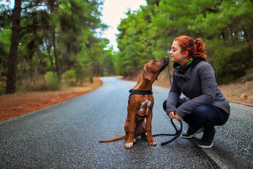 Portrait of happy teenage girl and Rhodesian ridgeback dog . Dog giving girl sweet kiss lick. Love animals love my pet