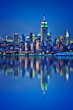 Photo of New York City skyline, Empire State building illuminated with water reflections at night
