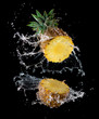 Slice of yellow pineapple with water splashing isolated on black background