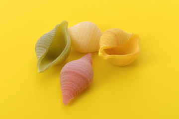 Pasta conchiglie on yellow background