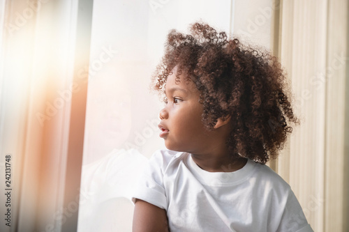 Small Child Little Girl Curly Hair Near The Window Kaufen