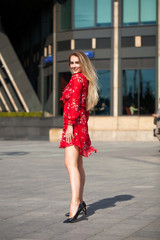 Poster - Sexy blonde model posing on th street in red summer dress