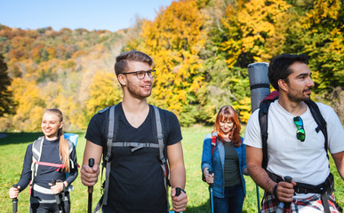 Wall Mural - smiling man trekking with friends in the nature, hikers exploring places