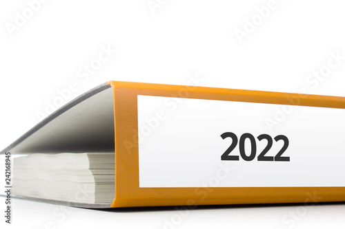 Fotografia oranger Aktenordner gefüllt mit Papierseiten und Beschriftung 2022 liegend vor w