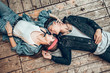 Top view of happy young stylish couple looking each other and smiling while lying on wooden floor. Lifestyle, modern concept.