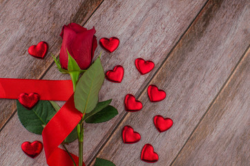 Red rose and Valentines day hearts on wood. Top view with copy space