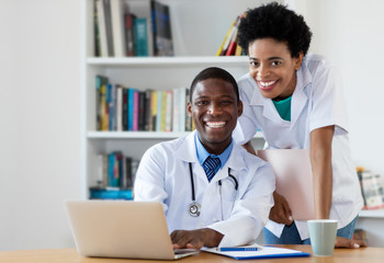 Wall Mural - African american doctor with nurse looking at camera