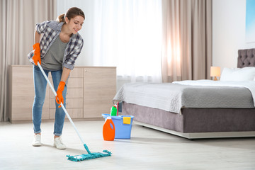 Sticker - Young woman washing floor with mop in bedroom, space for text. Cleaning service