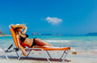 © Masson - Young redhead girl in black bikini and with hat lying down on lounger on Balos beach, west Crete, Greece. Summertime season vacation, July