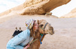 The woman touches with lips a muzzle of a camel in the Jordanian desert.