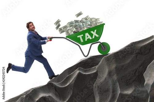 Fotografía Businessman pushing tax wheelbarrow uphill