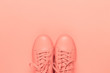 Pair of coral shoes on coral background. Trendy color of 2019. Monochrome image.