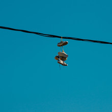 Sneakers Hanging On A Sky Background. The Concept Of Urban Kultruta, Sale Of Prohibited Substances, Ghetto