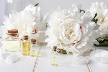 A Bottle Of Peony Essential Oil With Fresh Peony Flowers