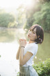 © Oran Tantapakul - portrait of asian girl with white shirt and skirt looking in outdoor nature vintage film style