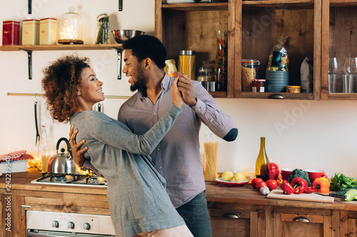 Fotomural Young african-american couple dancing in kitchen, copy space