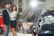 © serhiibobyk - Automobile headlight and couple standing behind.