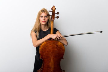 Wall Mural - Young blonde girl with her cello posing on white wall