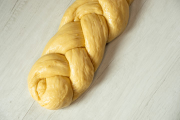 Wall Mural - Raw loaf of challah jewish bread on wooden background. Top view flat lay.