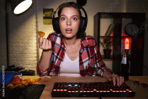 Fotomural Excited girl wearing headset playing online games