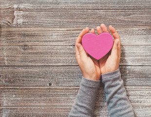 Wall Mural - Person holding heart shaped gift box in her hands