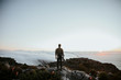 © Alina Schessler - Rear view of man standing on rock