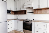 Fototapeta Panele -  Luxury modern kitchen furniture in grey color and steel oven,fridge, sink, wooden tabletop. Gray cabinets in scandinavian style. Home renovation. Stylish kitchen interior design.