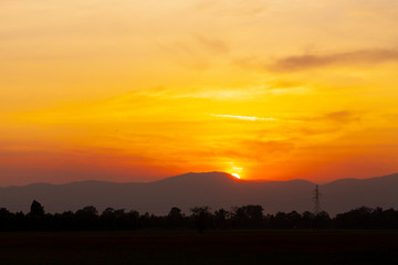 Wall Mural - sunset silhouette on mountain and have high voltage pole . landscape image of countryside for wallpa