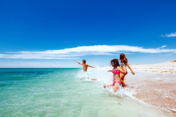 Teenage friends playing on the beach