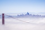 Fototapeta  - Golden Gate and the San Francisco bay covered by fog, the financial district skyline in the background, as seen from the Marin Headlands State Park, California