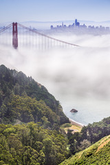 Golden Gate and the San Francisco bay covered by fog, the financial district skyline in the background, as seen from the Marin Headlands State Park, California