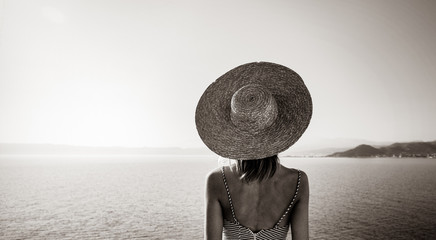 Young redhead girl in hat and dress with sea coastline on Balos, Crete, Greece