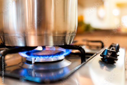 Fotomural Macro closeup of modern luxury gas stove top with blue fire flame knobs and stai