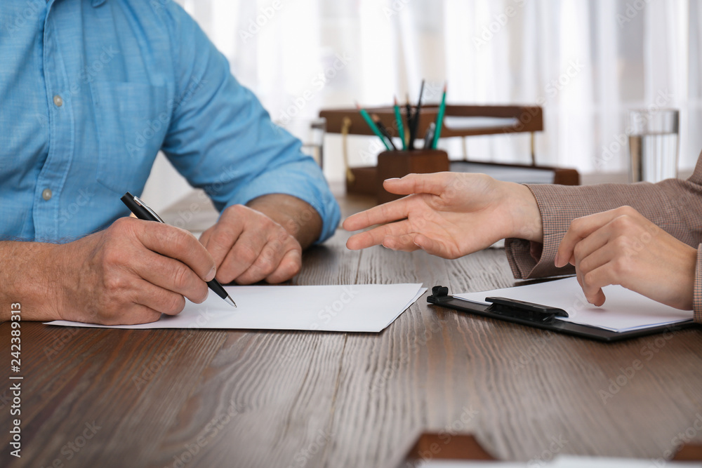 человек подписывает документы с юристом