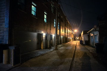 Shadow of a person in a dark scary alley at night