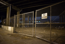 Dark And Scary Abandoned Area With A Fence Under A Highway City Bridge At Night In Chicago