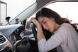 © comzeal - Tired young woman sleep in car, Hard work causes poor health, Sit asleep while the car is on a red light, Traffic jam or overworked concept