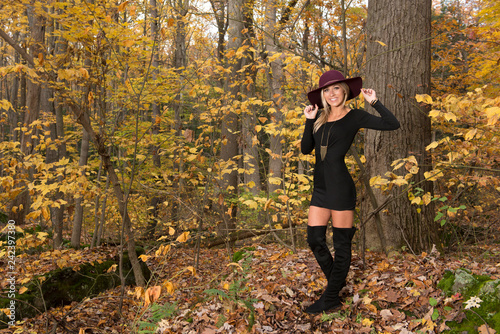 Fotomural Sexy young blonde woman in stunning black dress and over the knee boots wears a