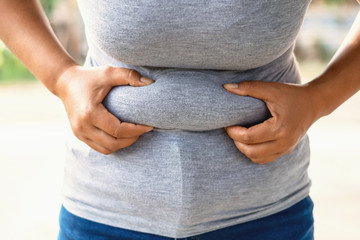 woman body fat hand holding belly front view