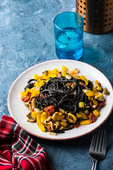 Wall Mural - Black pasta with seafood, anchovies, tomatoes and bell peppers.